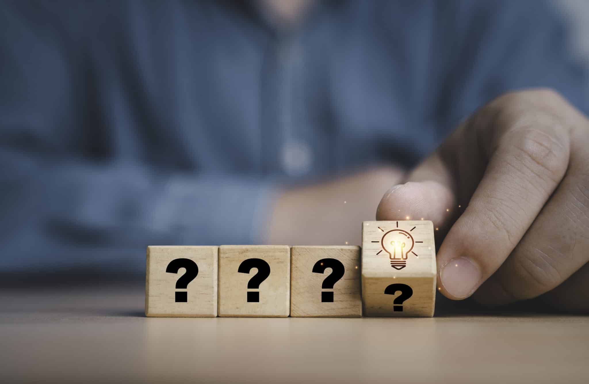 Hand flipping wooden block cube from question mark to glowing light bulb, Breaker box upgrade.