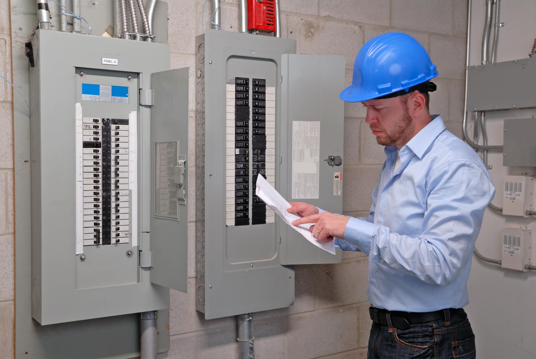 Maintenance, Electrician looking at file in front of control panel in utility room, Panel surge rating.