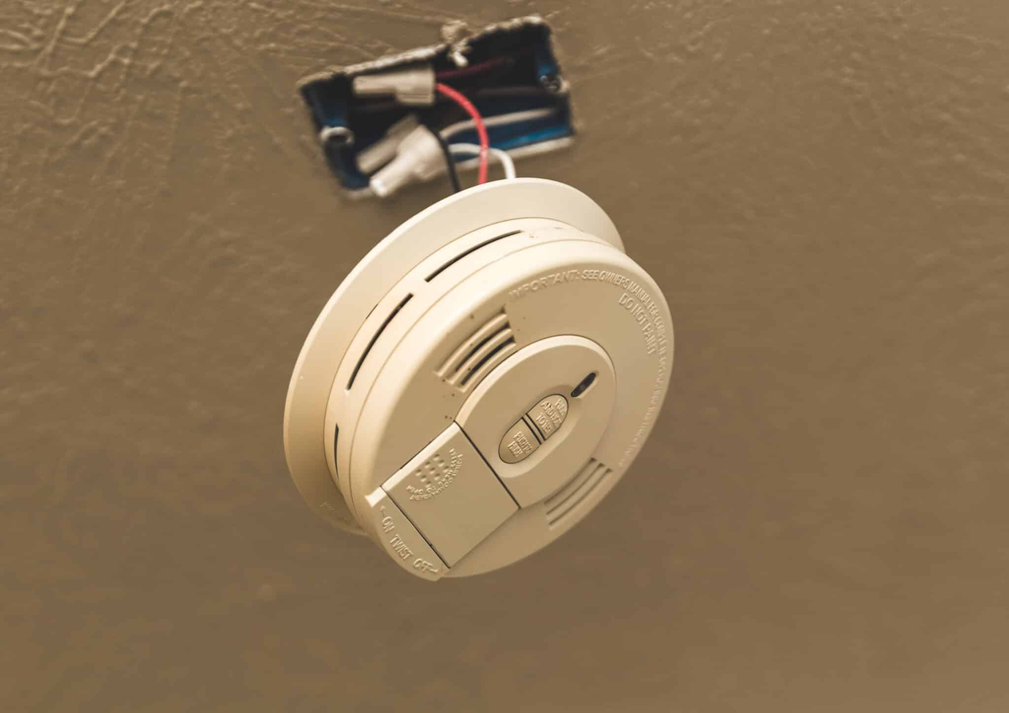 Smoke alarm dangling by wires from the ceiling, Smoke alarm interlinking.